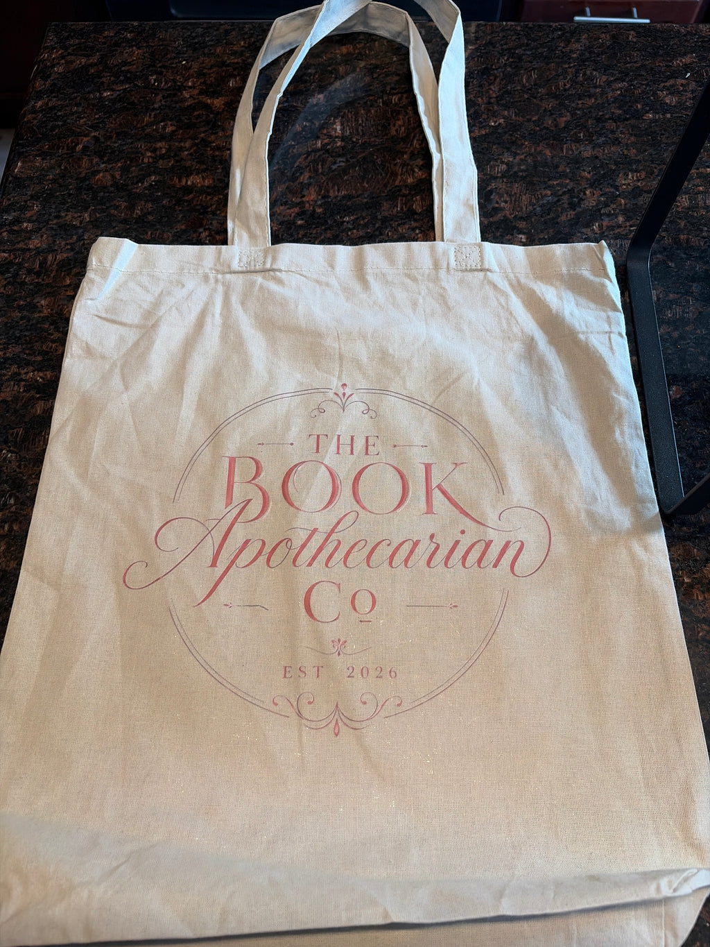 The Book Apothecarian Co tote bag - flat lay showing full logo print